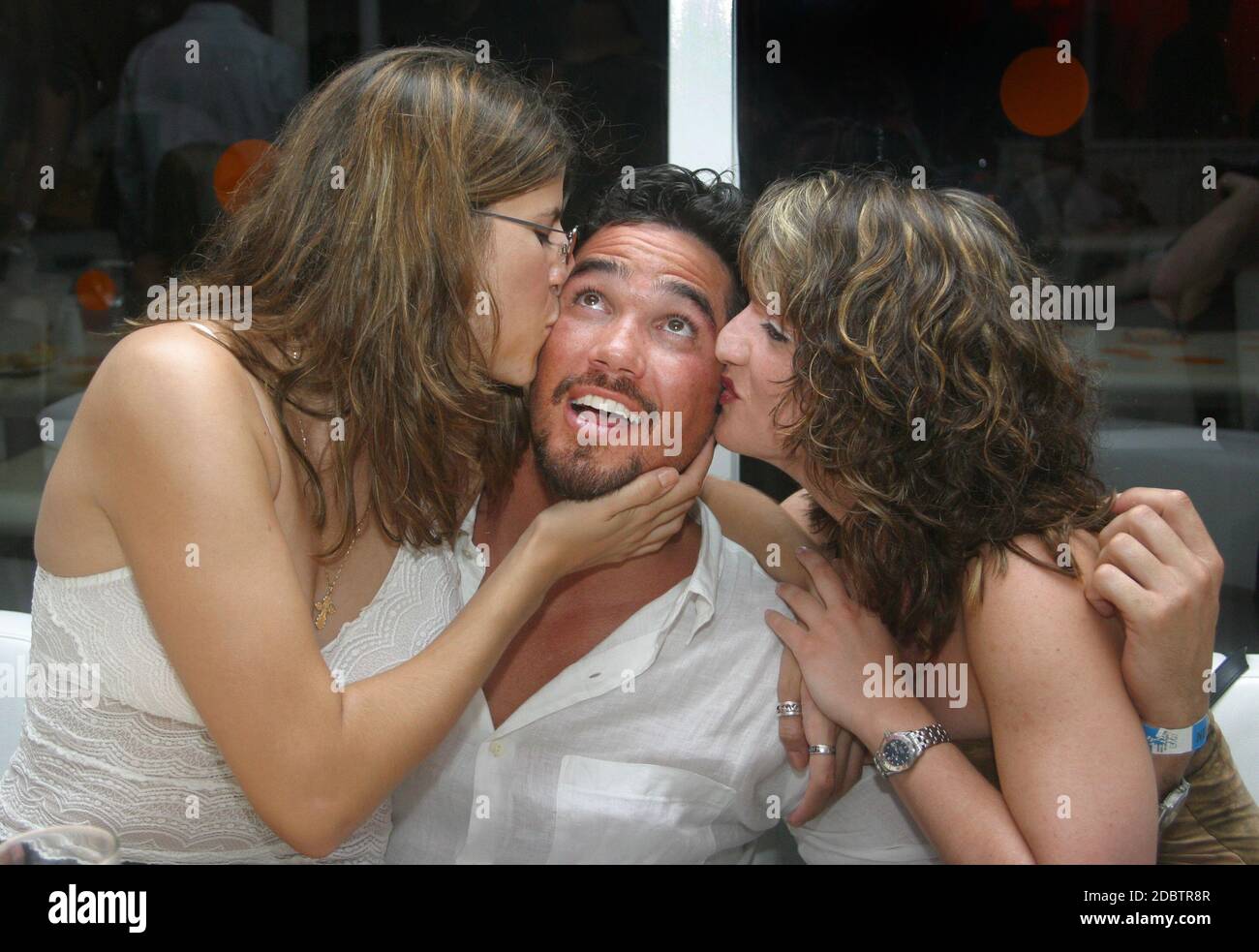 Miami Beach, FL 7-8-2002Dean Cain (TV's Superman) looks to the heavens while getting bussed by two friends at Nikki Beach Club. Photo by Adam Scull-PHOTOlink /MediaPunch Stock Photo