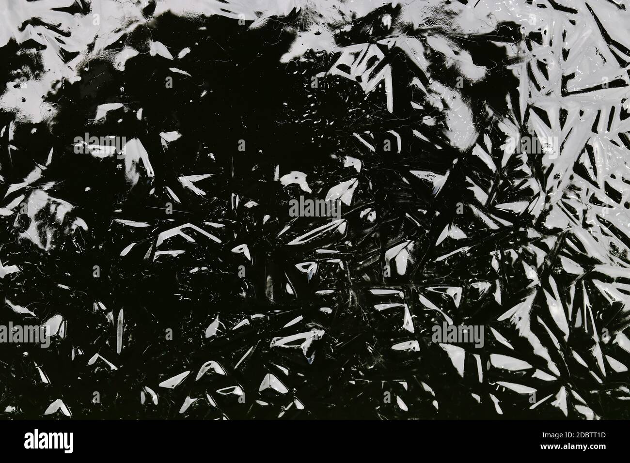 An abstract pattern in black and grey has been created on frozen water Stock Photo