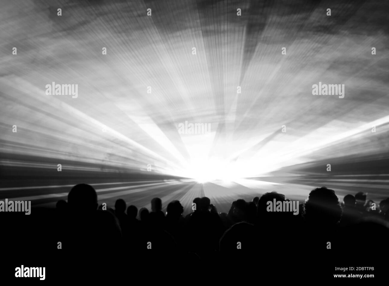 Luxury entertainment with audience silhouettes in nightclub event, festival or New Years Eve. Beams and rays shining colorful lights. Stock Photo