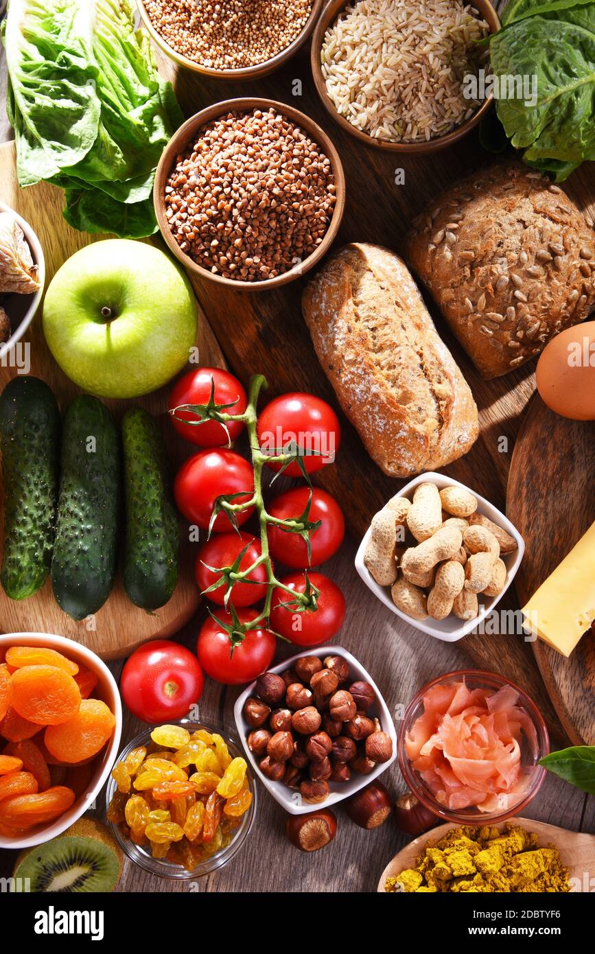 Composition with assorted organic food products on wooden kitchen table ...