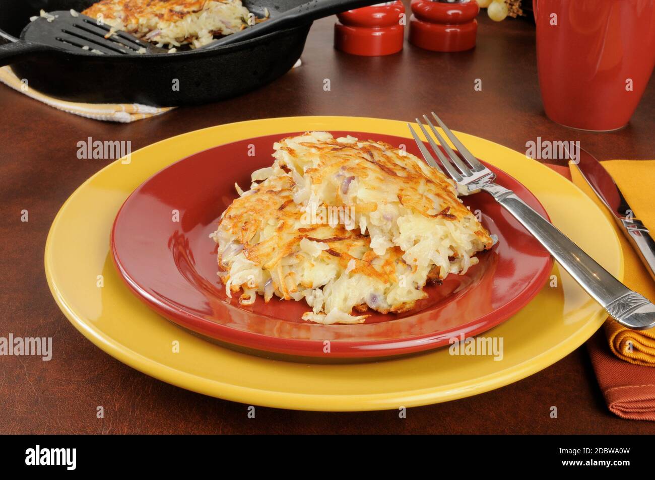 A plate of potato latkes with a cast iron skillet in the background Stock Photo Alamy