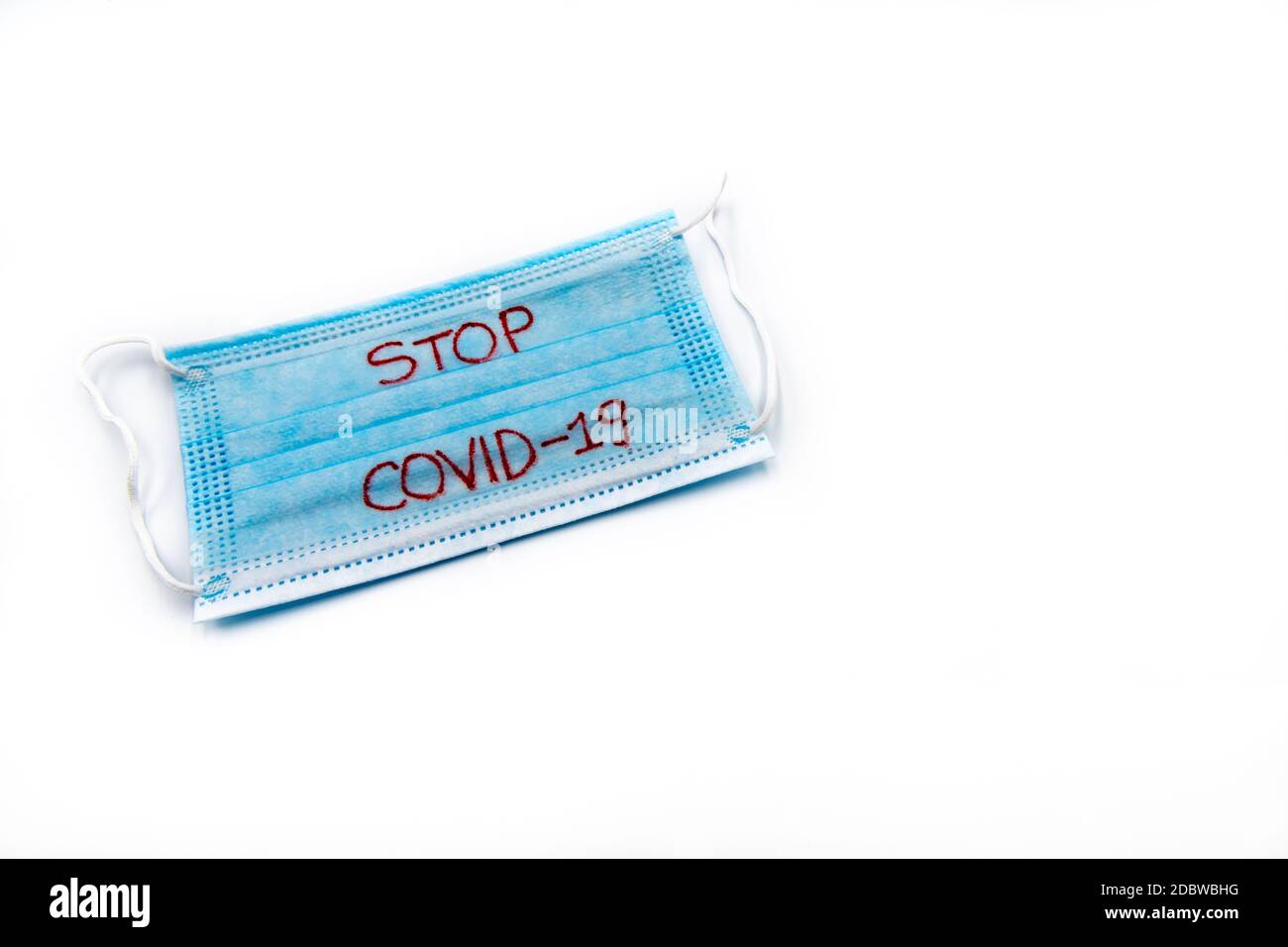 Single use medical face mask with handwritten message Stop Covid19