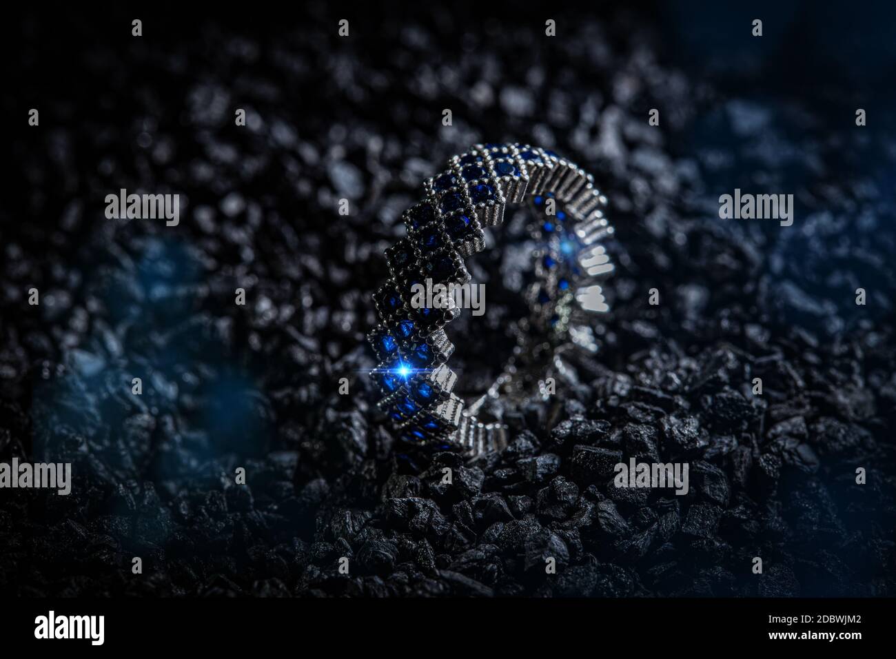 Silver ring with blue stones on black coal background Stock Photo