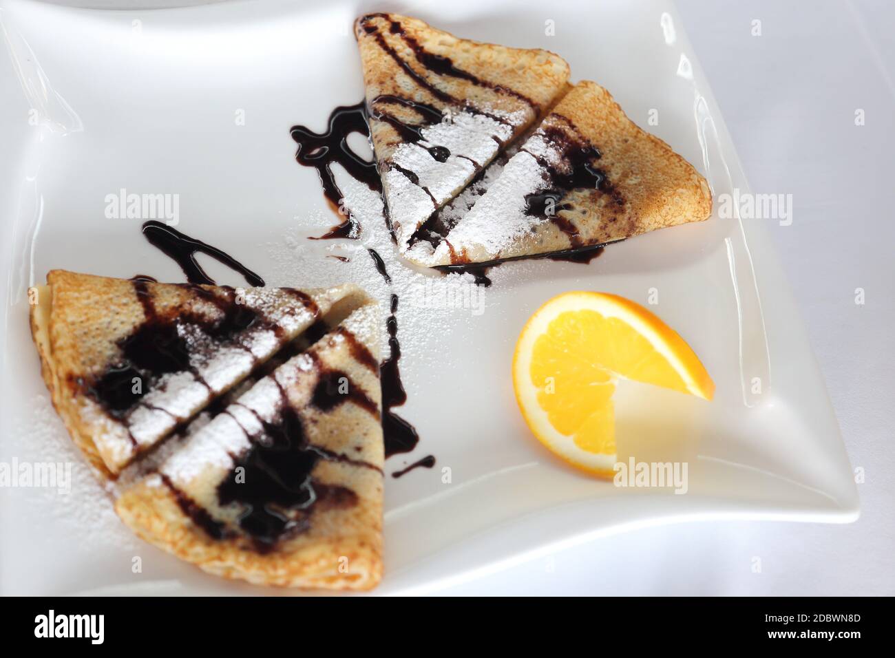 some pancakes with chocolate and sugar on a plate Stock Photo