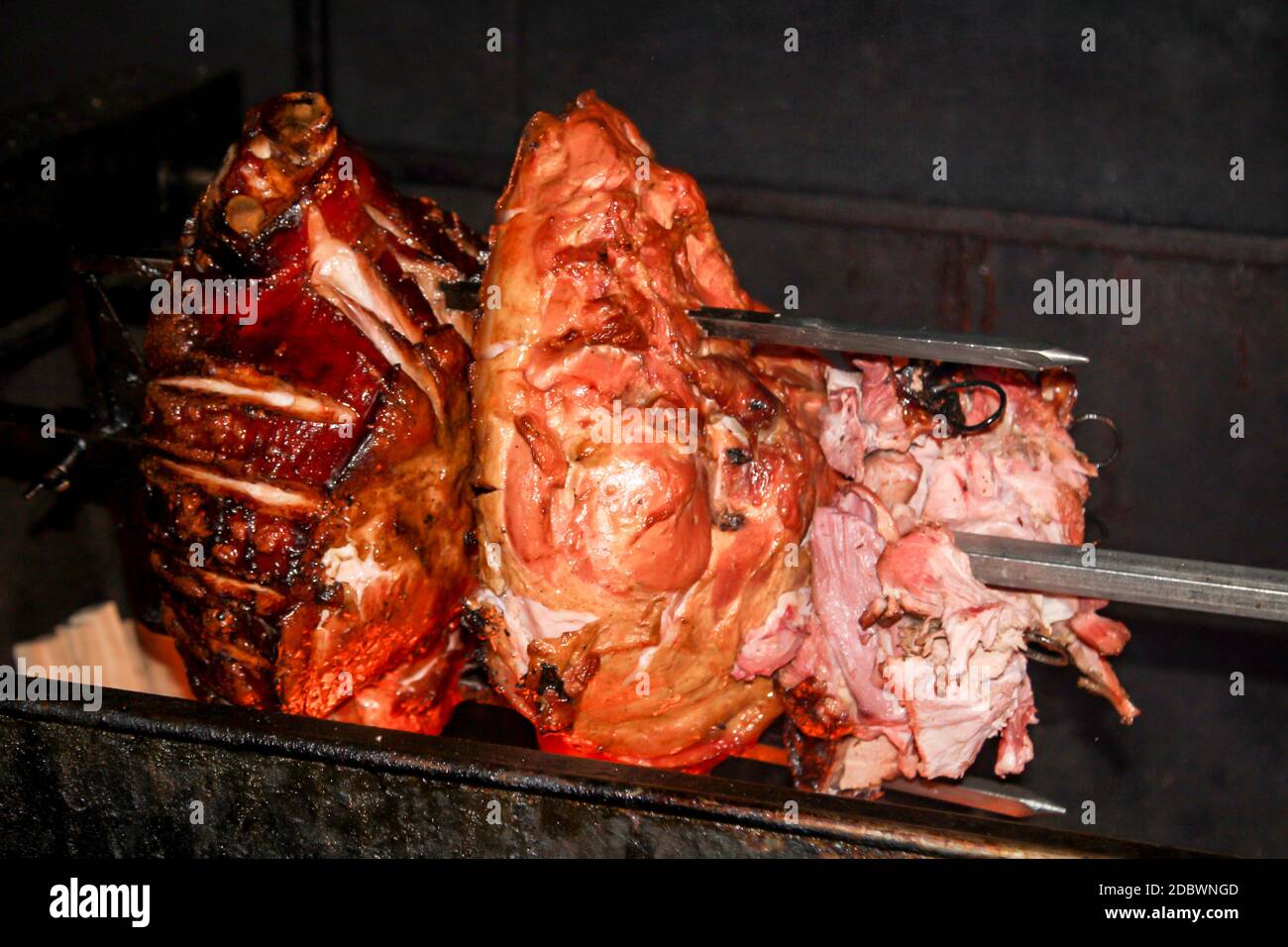 A roast pork on a skewer over a grill Stock Photo