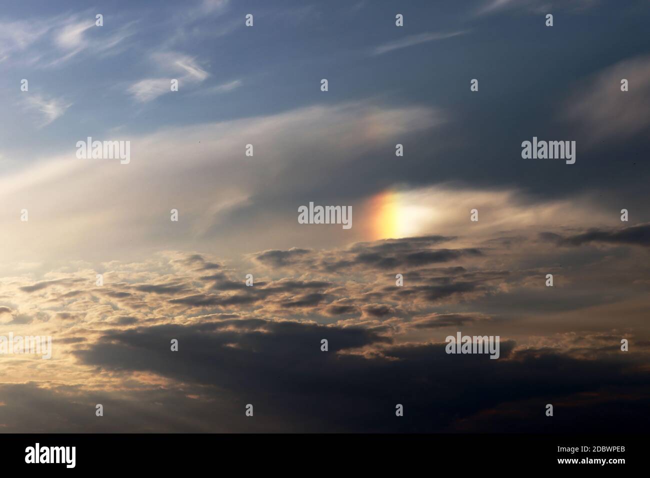 A part of a halo (light effect) in the evening sky between clouds Stock Photo