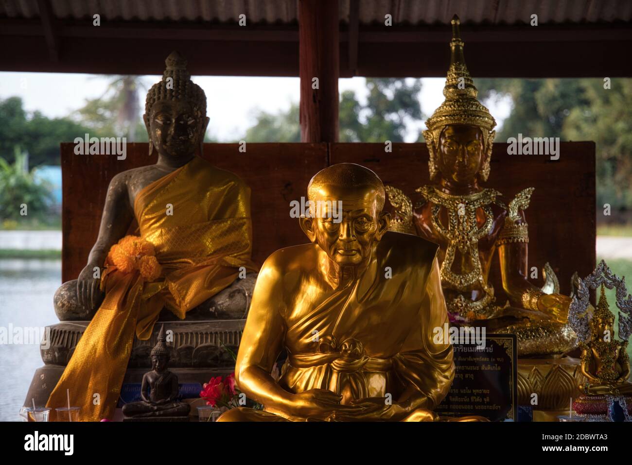 Three beautiful golden Buddha statues sitting and meditating outside in front of a temple in Hua Hin Thailand. Stock Photo