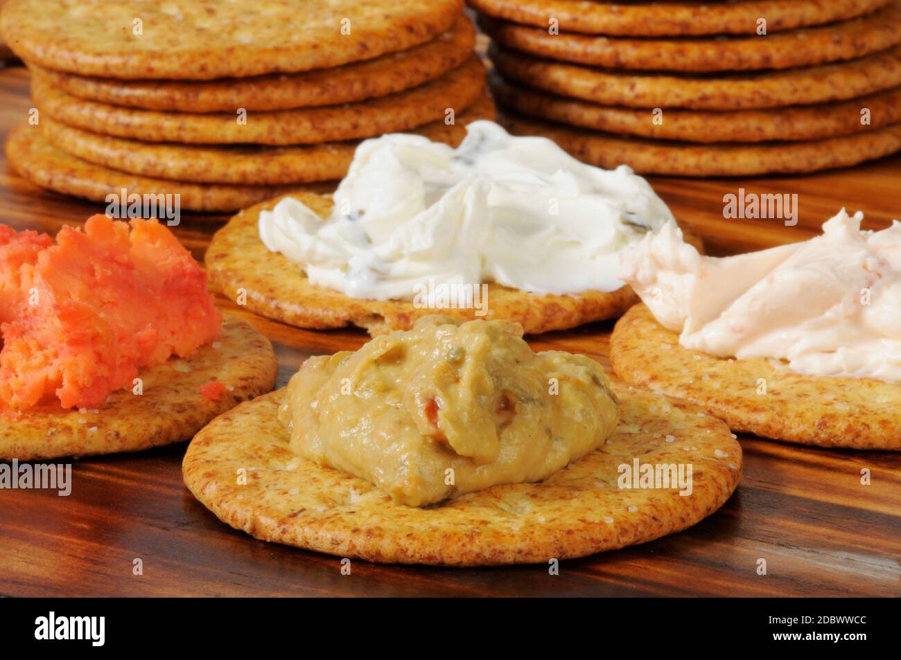 Crackers with assorted dips including cream cheese and chives, hummus, and port wine cheddar cheese Stock Photo