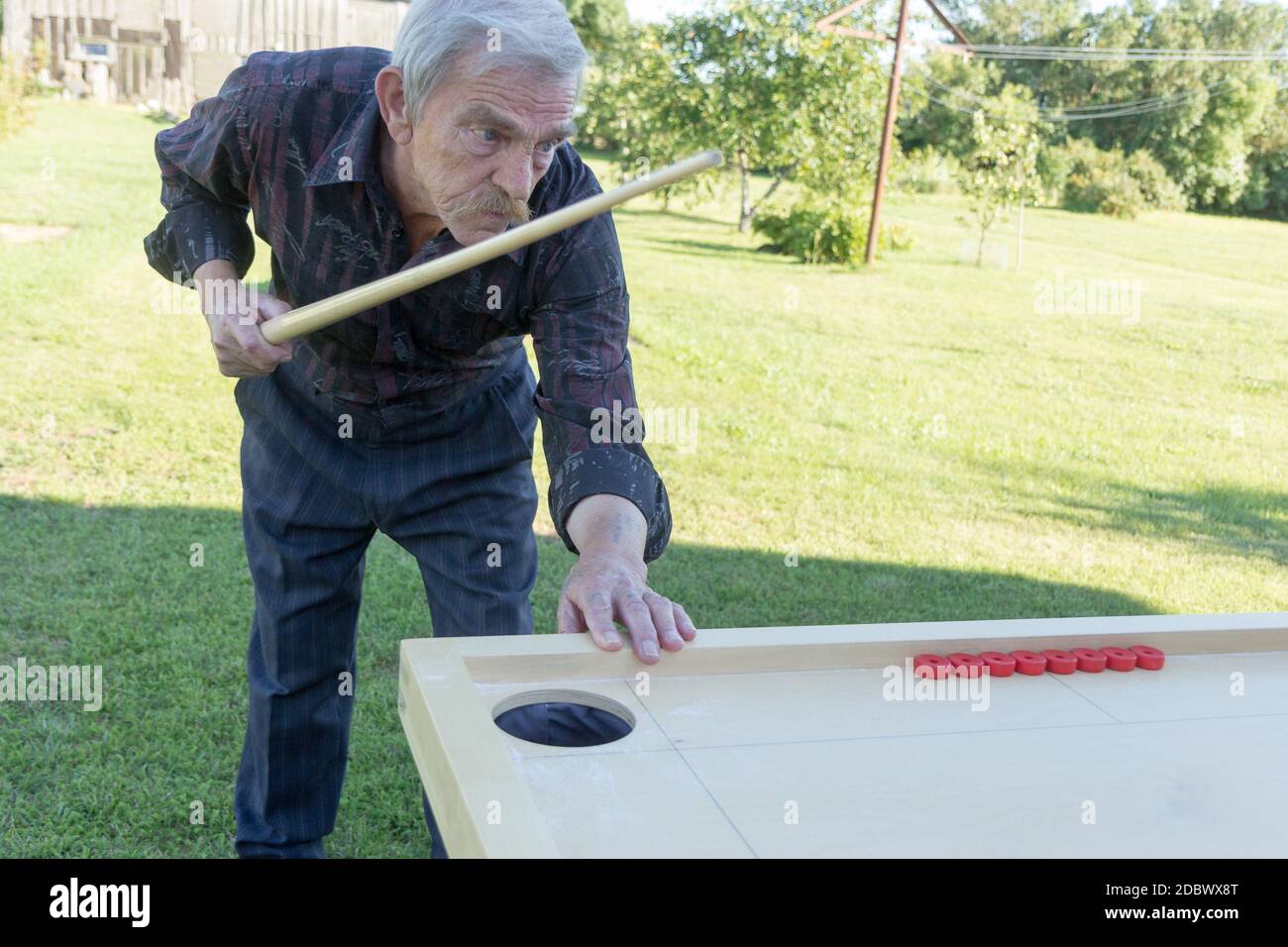 Man playing Novuss in outdoors. Novuss is a national sport in Latvia similar to pocket billiards or pool. Stock Photo