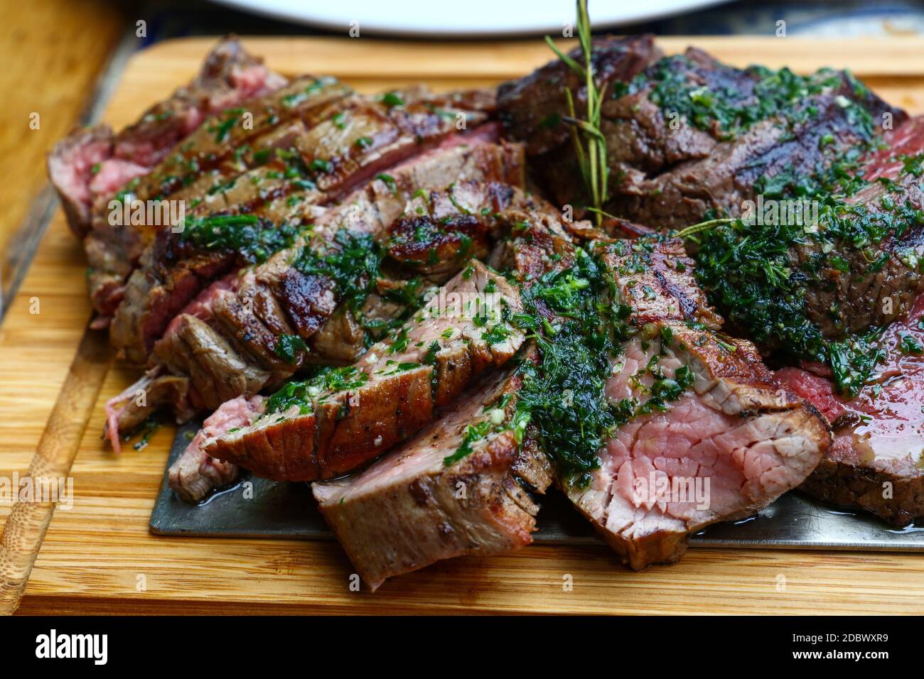 Close up big portion of sliced grill roasted beef chateaubriand tenderloin  meat with thyme and herbs served on wooden cutting board, high angle view  Stock Photo - Alamy