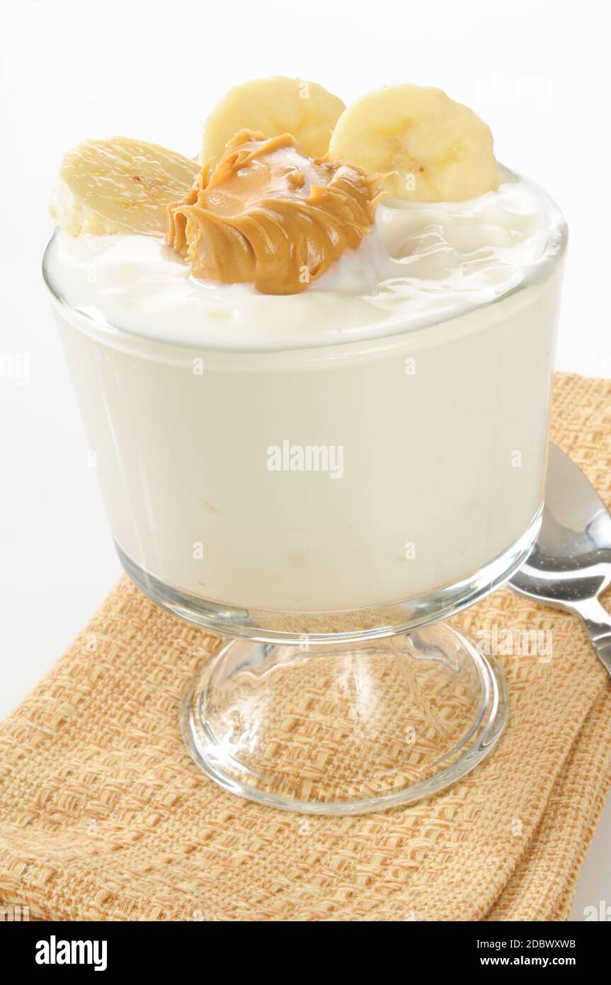 A glass cup of vanilla yogurt with peanut butter and banana Stock Photo