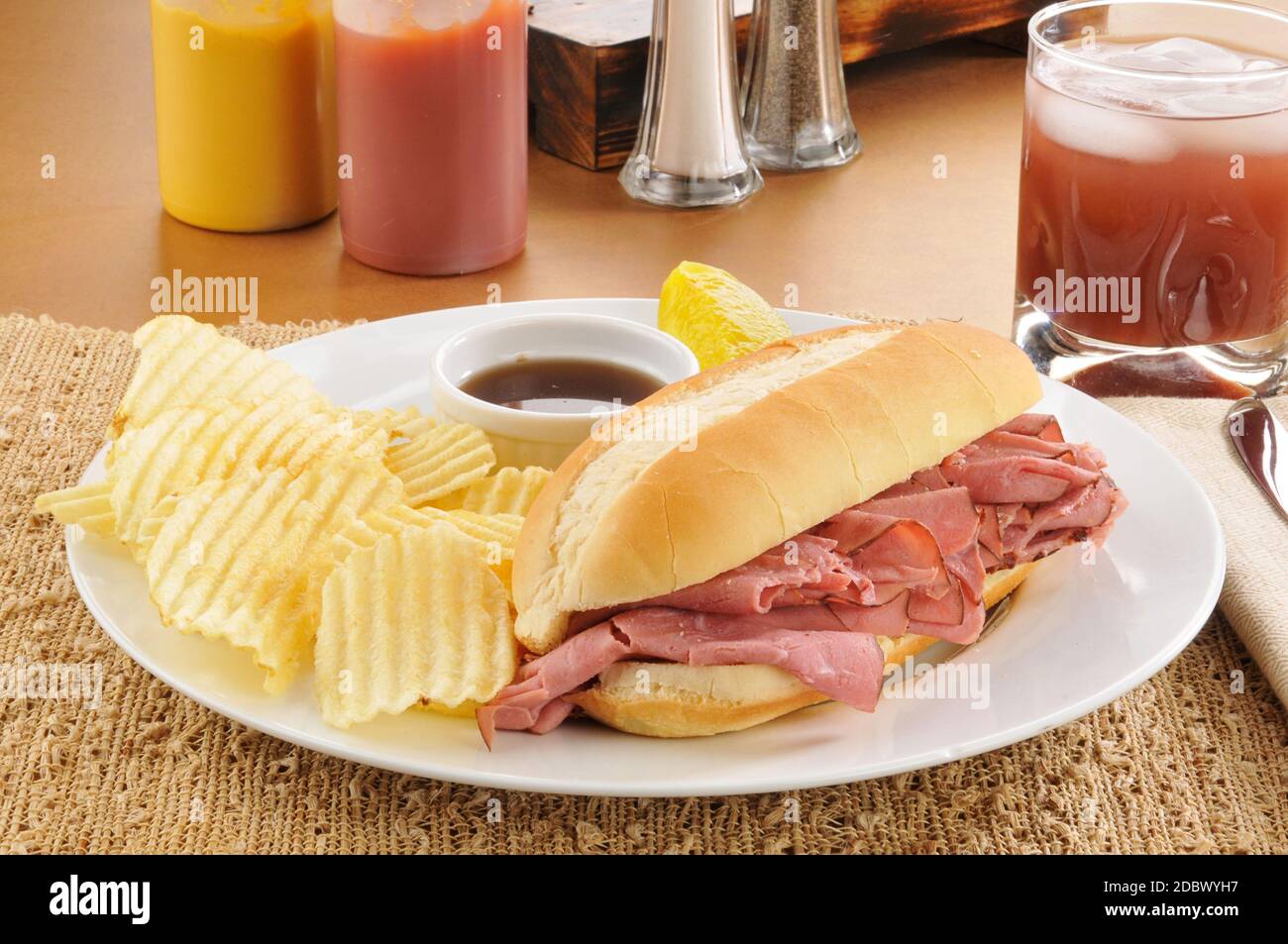 Roast beef sandwich au jus with potato chips and juice Stock Photo Alamy