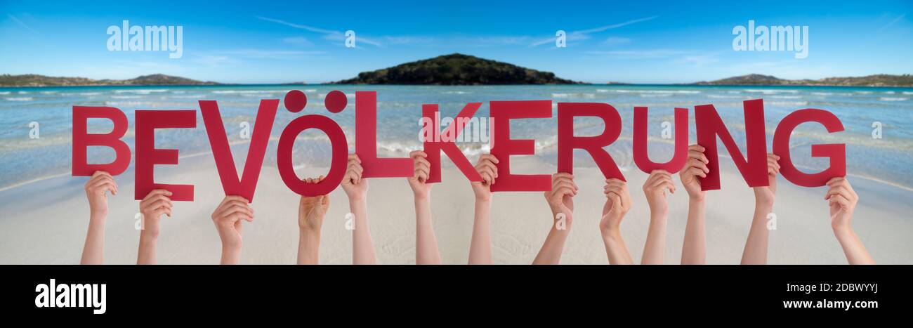 People Hands Holding Colorful German Word Bevoelkerung Means Population. Ocean And Beach As Background Stock Photo
