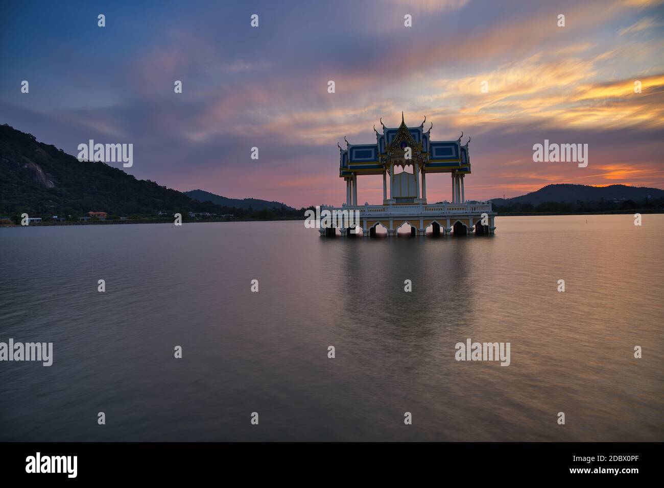 Buddhist shrine on a lake in Hua Hin in Thailand at sunset! The temple is reflected in the water and the sky turns red! Stock Photo