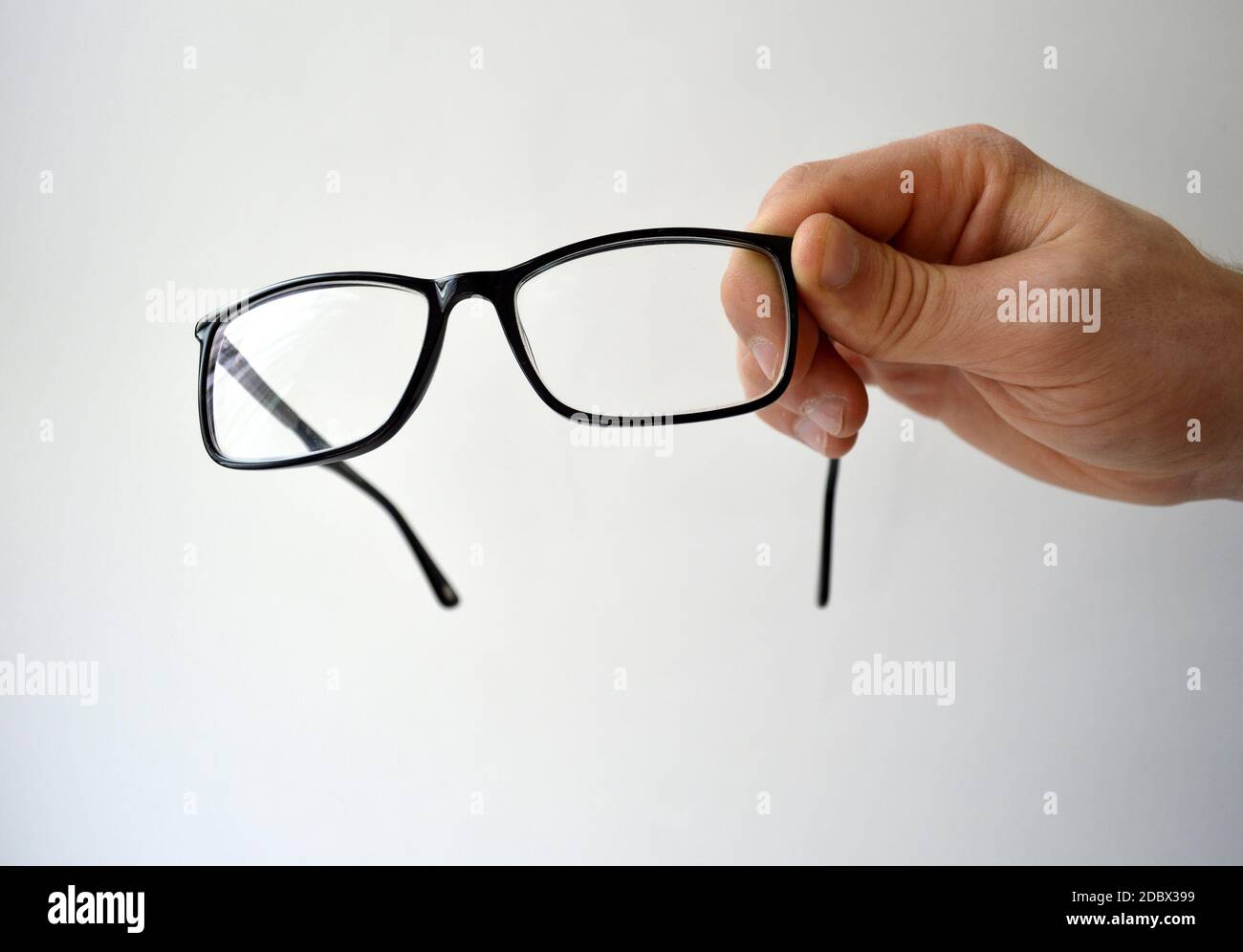 Black glasses in man's hand isolated on white background Stock Photo