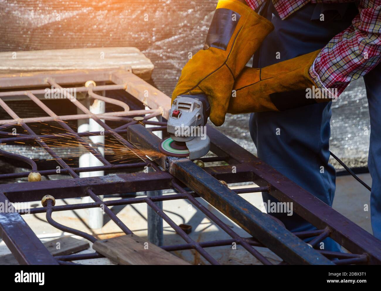 Worker wearing safety leather gloves and grinding arc welding strikes