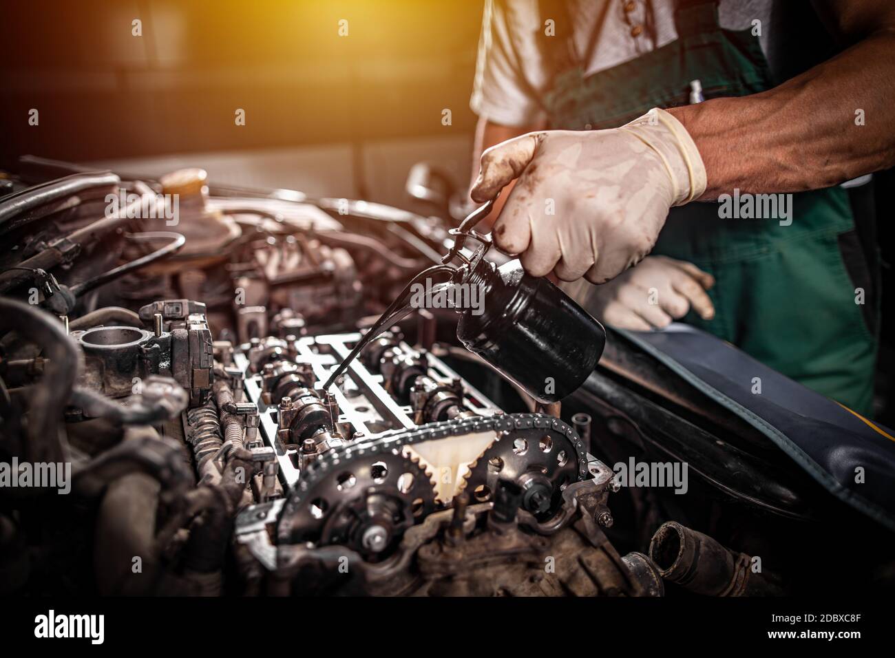 Motor oil pouring to car engine. Repair service concept Stock Photo - Alamy