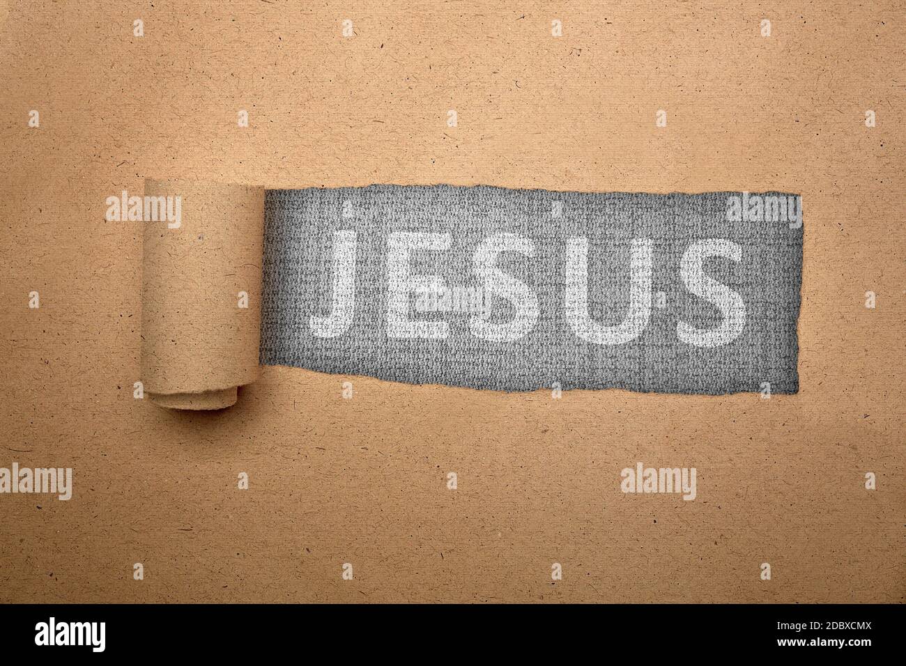 Ripped paper with Jesus text on black background Stock Photo - Alamy