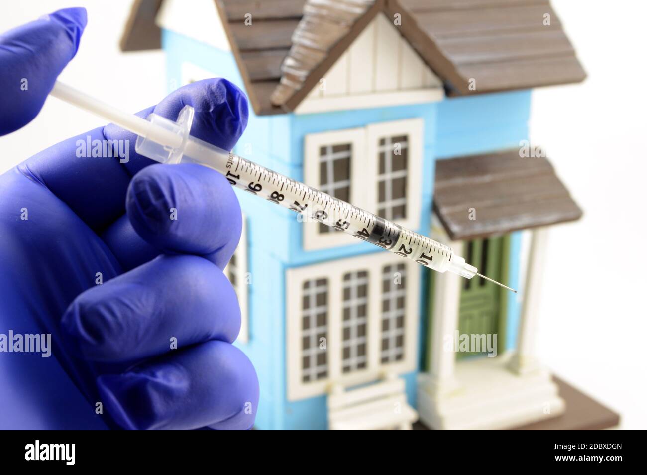 A concept of a medical professional preparing a vaccine for quarantine households affected by Covid-19 Coronavirus edpidemic. Stock Photo