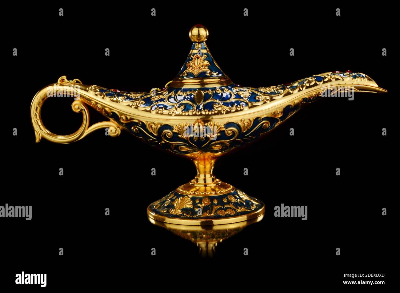 An isolated over black background golden magic genies lamp. Stock Photo