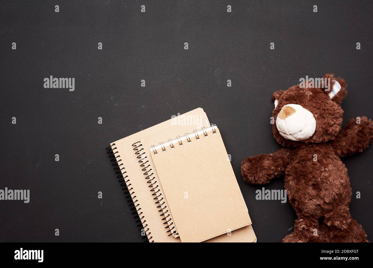 stack of notebooks with blank white sheets and a brown teddy bear on a ...
