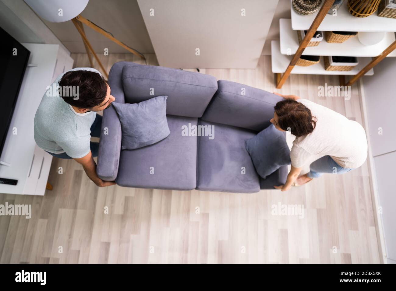 Couple Moving And Carrying Sofa Furniture Or Couch Stock Photo Alamy