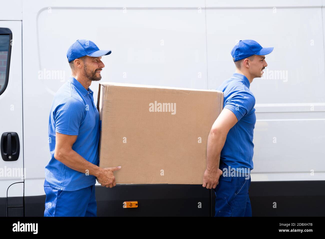 Delivery And Removal. 2 Movers Near Van. Side View Stock Photo