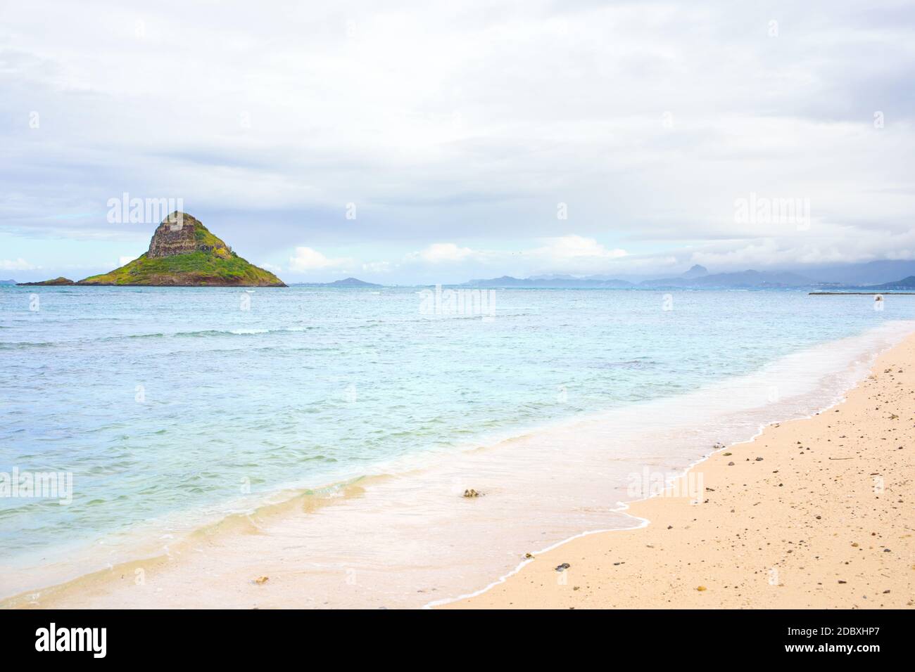 Empty Kualoa Beach Park on cloudy day with Mokoli'i Island (previously known as the outdated term 'Chinaman's Hat') island in background Stock Photo
