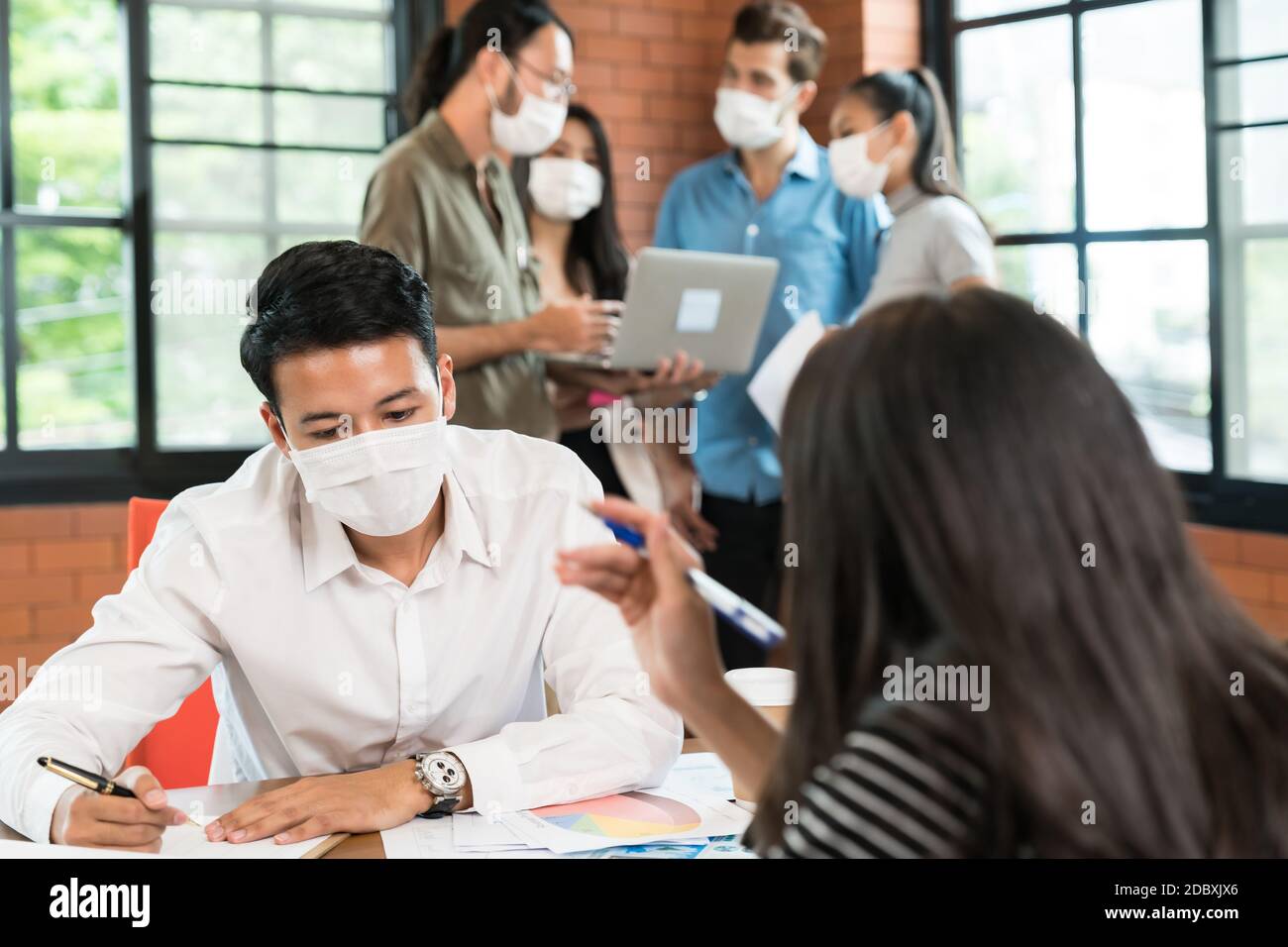 Two business person brainstorm in meeting room with group of ...
