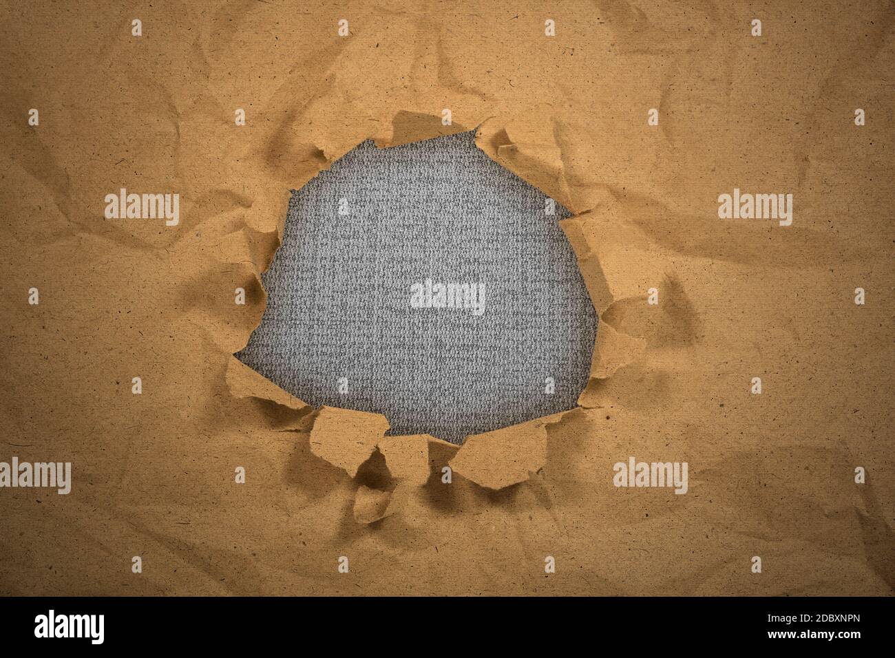 Paper with a hole torn in the middle with black background Stock Photo