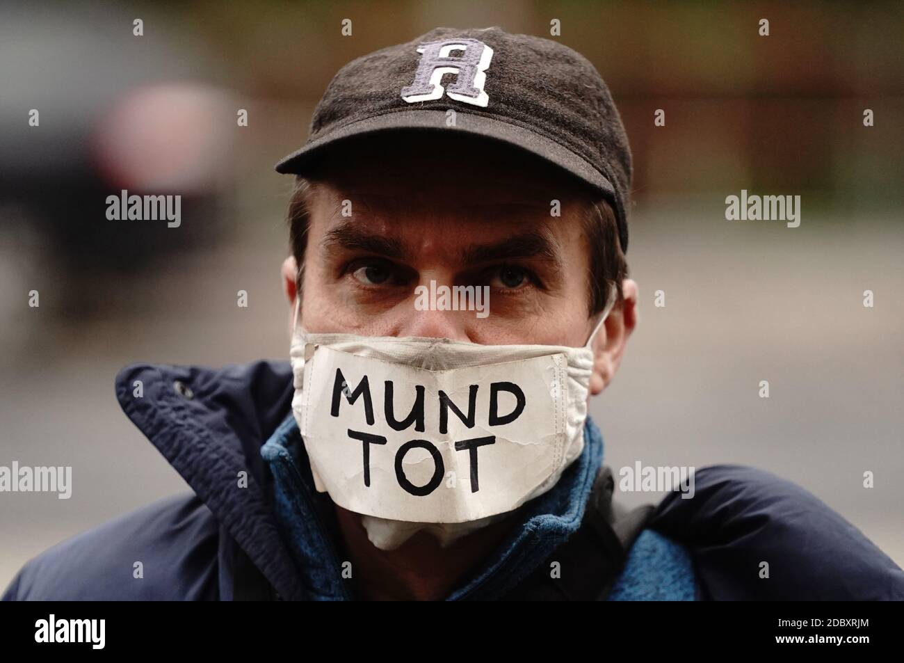 Berlin, Germany. 18th Nov, 2020. A participant of a demonstration against corona restrictions of the German government wears a mouth-nose cover with the inscription 'Mundtot' (dead mouth). The new version of the infection protection law is to be passed by the Bundestag and Bundesrat in a fast-track procedure. Credit: Kay Nietfeld/dpa/Alamy Live News Stock Photo