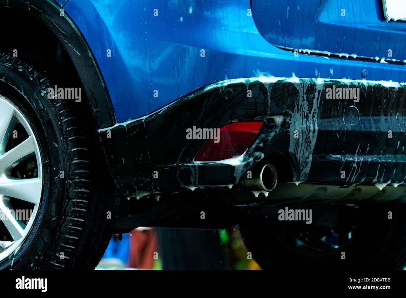 Blue car wash with white soap foam. Auto care business. Car cleaning