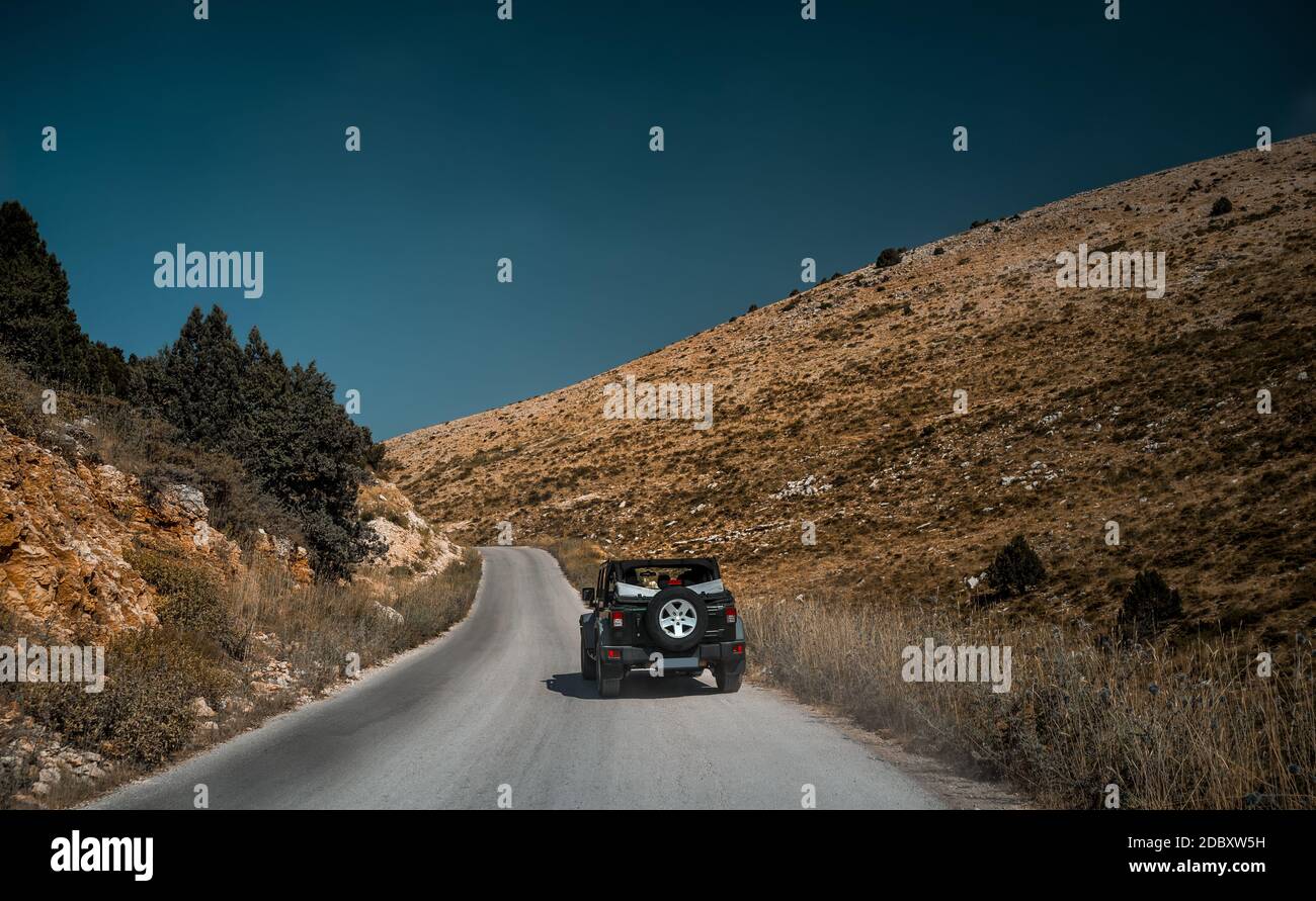 Off-Road Vehicle on Mountainous Road. 4x4 Car on the Road Trip Driving Along Lebanese Wild Landscape. Leisure Time. Active Summer Vacation. Stock Photo