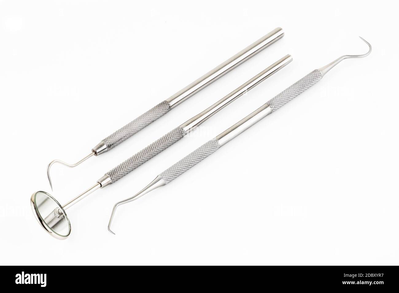 Dental mirror scaler and sickle probe explorer tools on a white