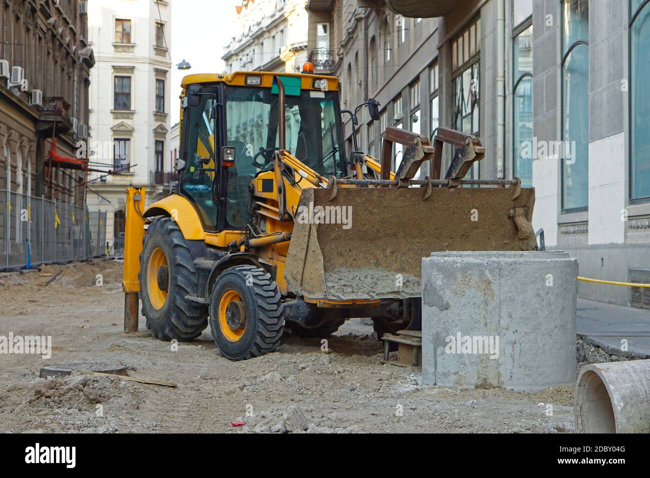 Backhoe loader at construction site in city Stock Photo - Alamy
