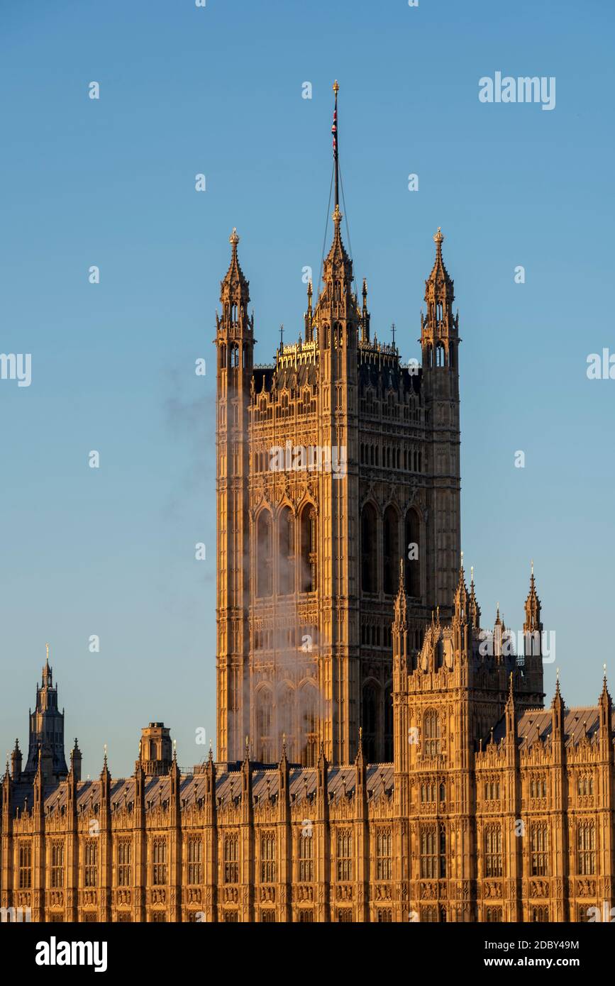 Smoke or steam rising from the Palace of Westminster, Houses of Parliament, on a bright, sunny but cold November day in London, UK. Victoria Tower Stock Photo