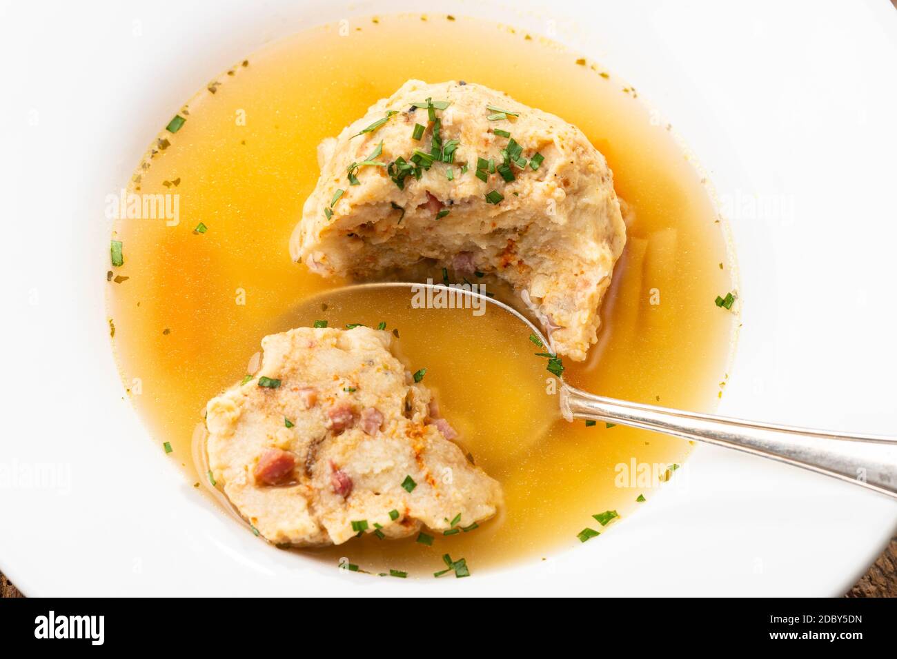 single speckknoedel in soup on wood Stock Photo
