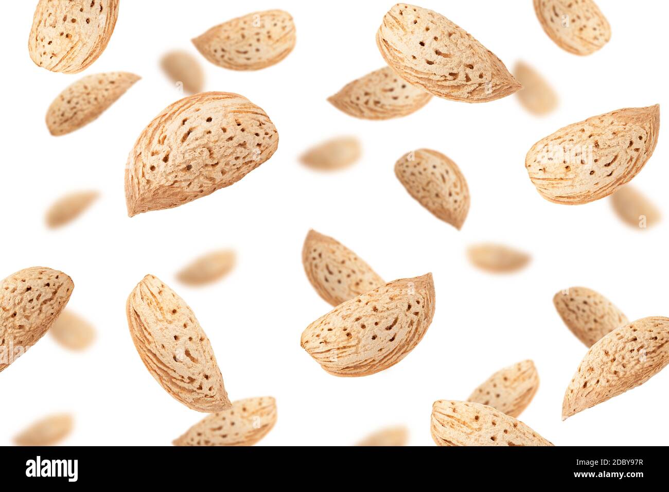 Falling Almond nut in shell isolated on white background, selective focus Stock Photo