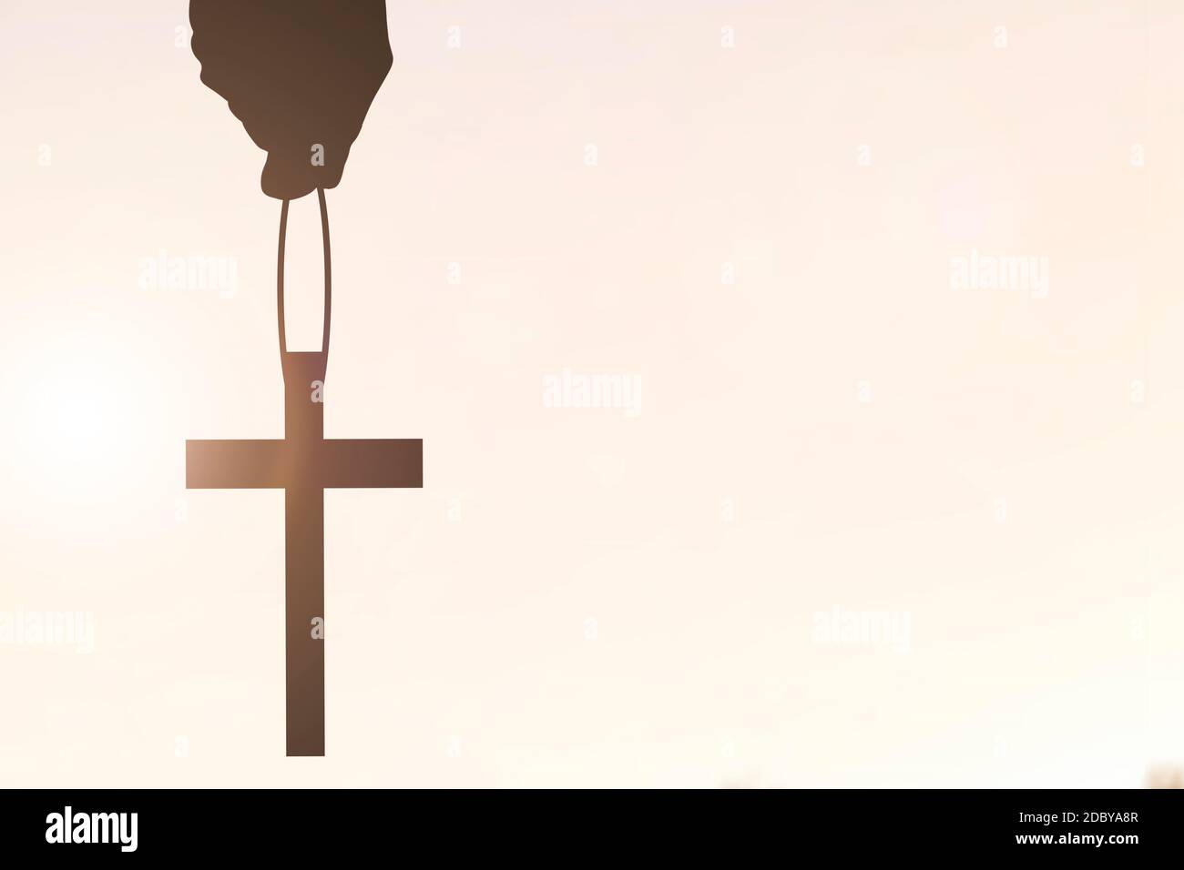 Human hand holding Christian cross with a sunset sky background Stock ...