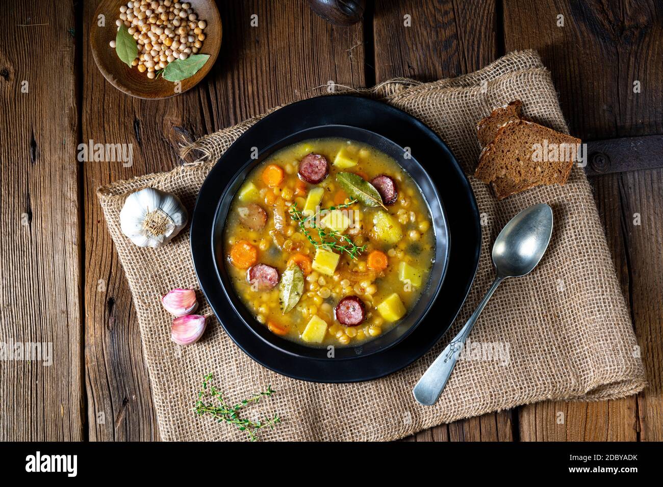 Rustic pea soup with bacon and sausages Stock Photo