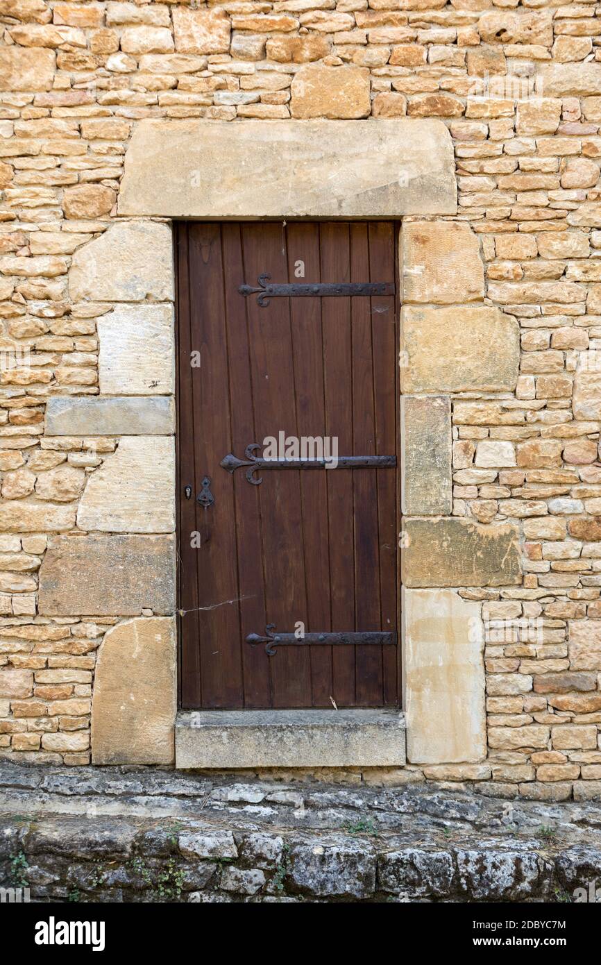 Old stone house with wooden door in Domme. Perigord, France Stock Photo ...