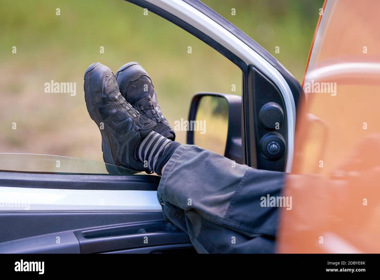 A worker in work clothes takes a break in his car Stock Photo