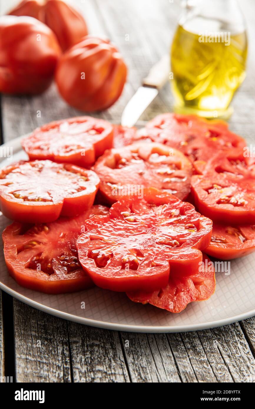 Sliced red beefsteak tomatoes on plate. Stock Photo