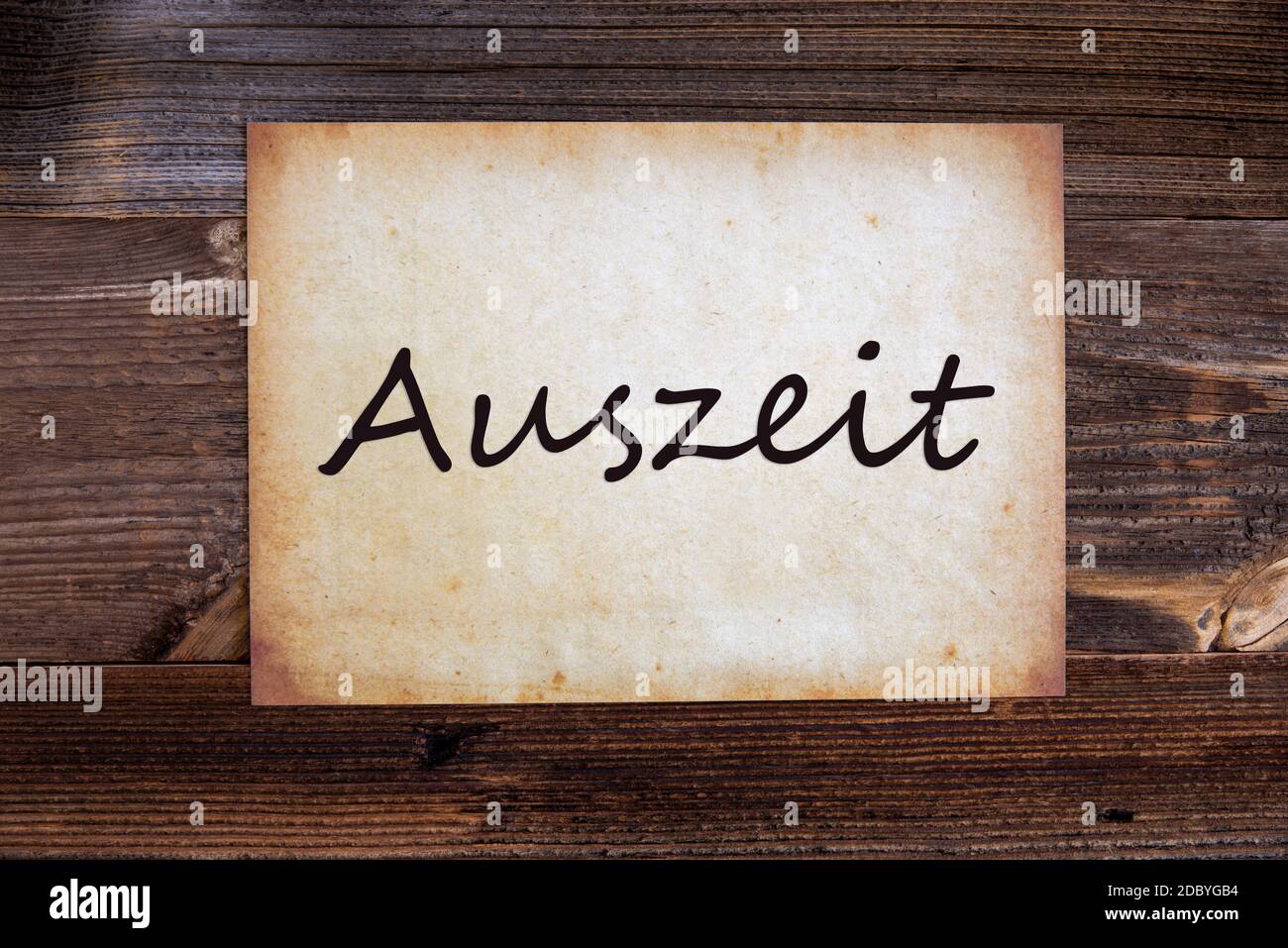 Old Grungy Paper With German Text Auszeit Means Relax. Wooden Background Stock Photo