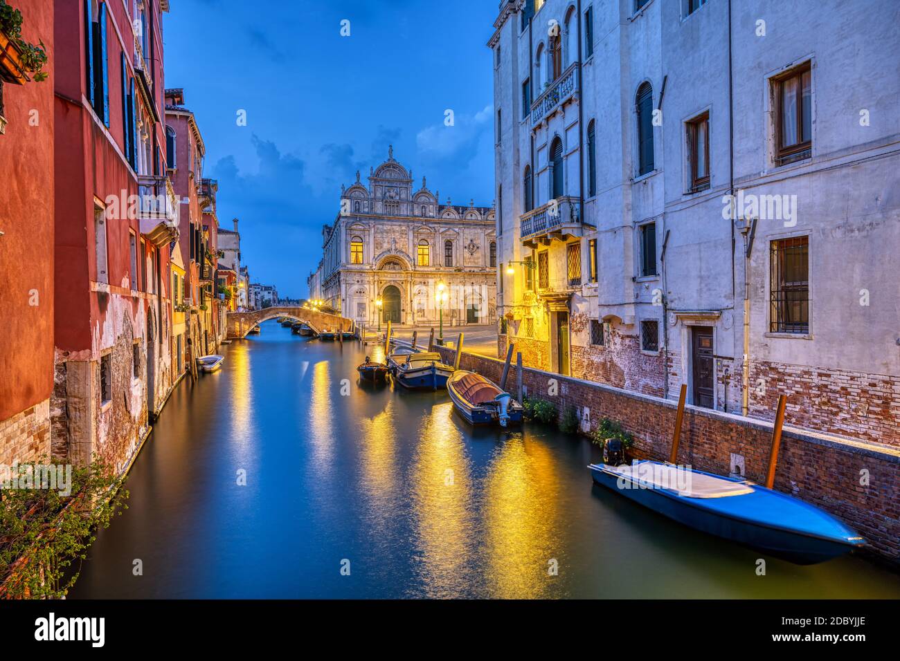 Canal in the old town of Venice at dusk with the Scuola Grande di San Marco in the back Stock Photo