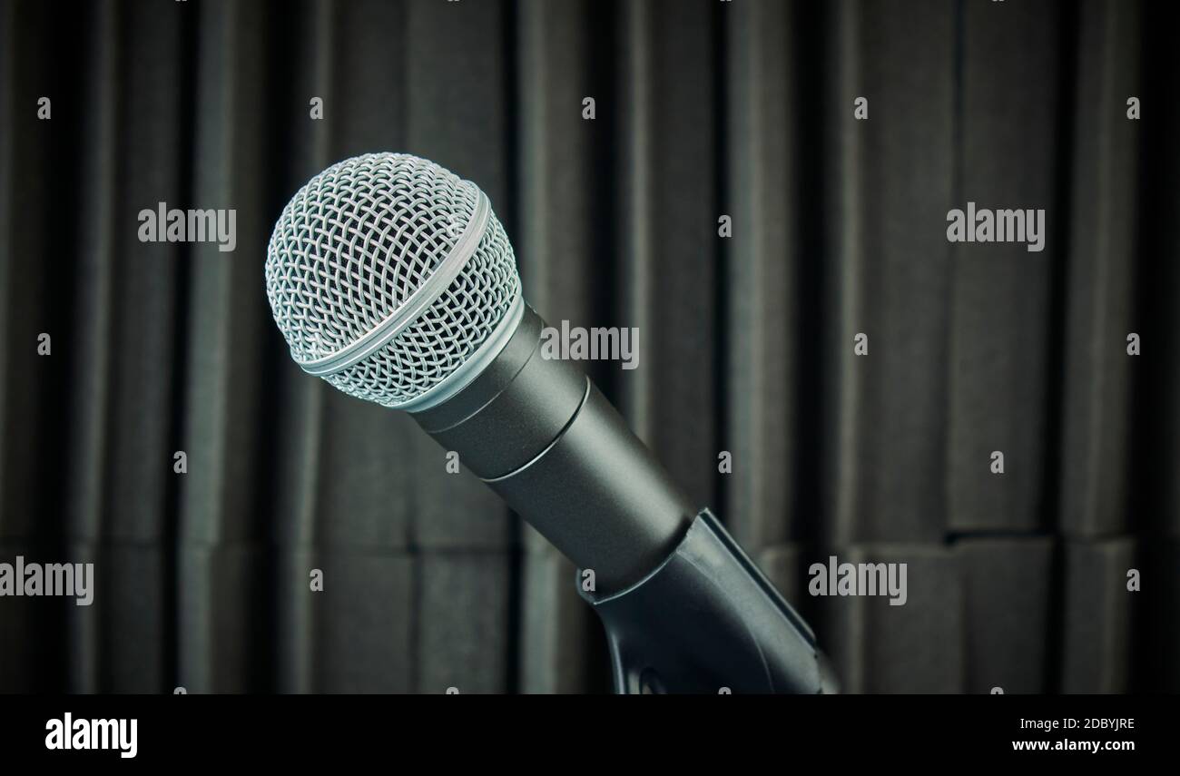 Side view microphone mounted on mic stand and acoustic foam background in gray tones Stock Photo