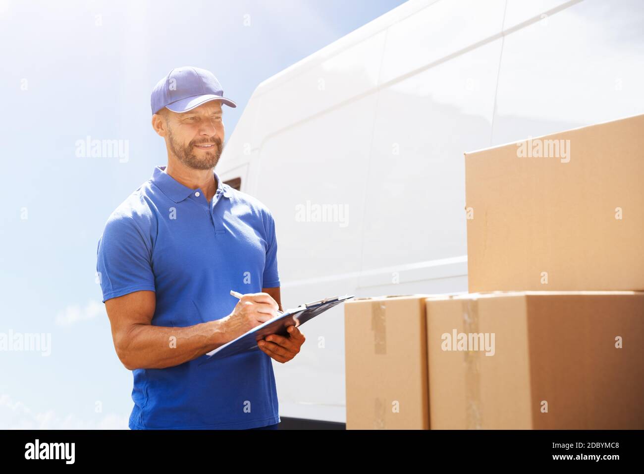 Professional Van Courier Unloading Boxes From Truck Stock Photo