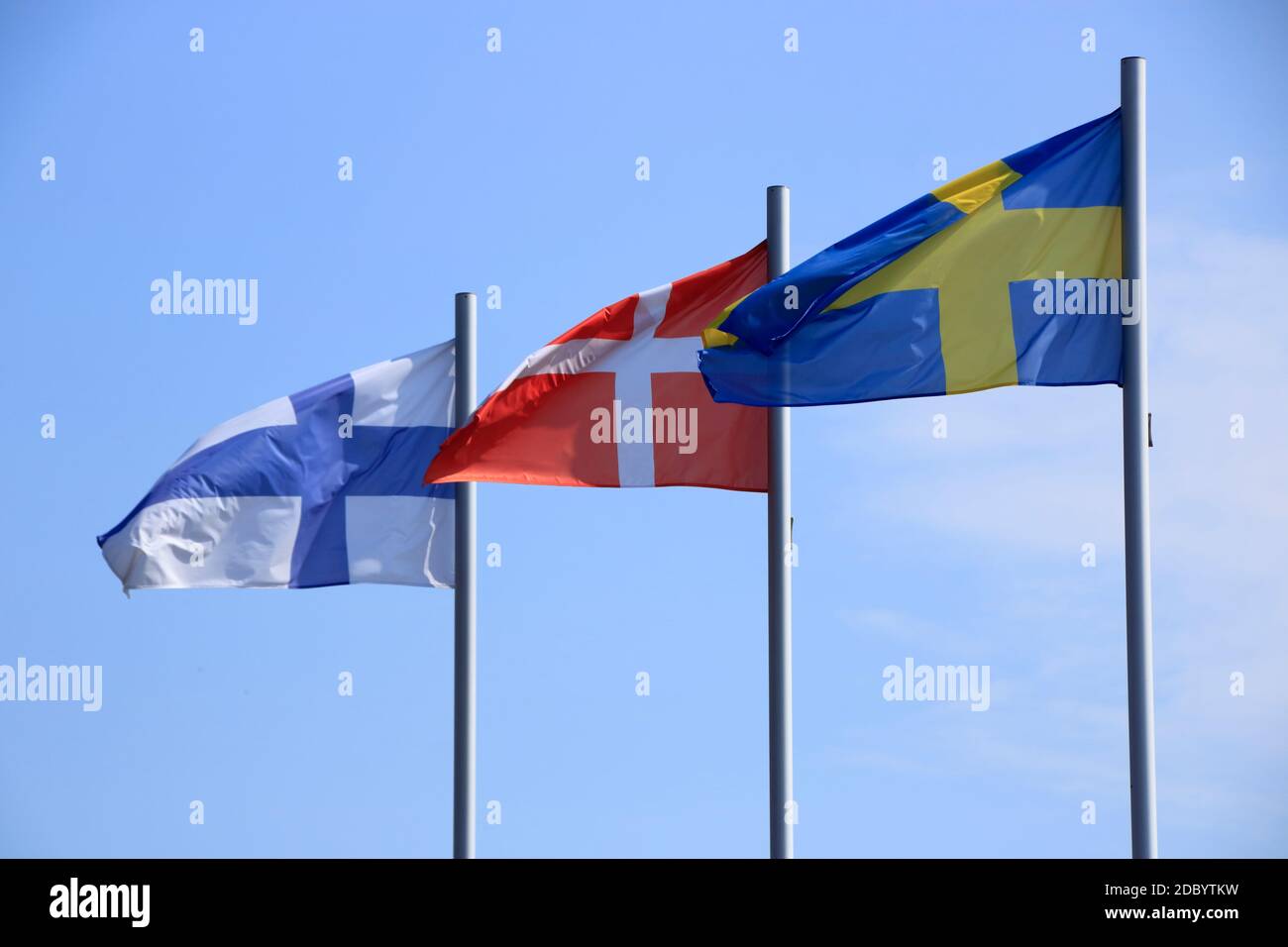 Flags blow in the wind against a blue sky Stock Photo
