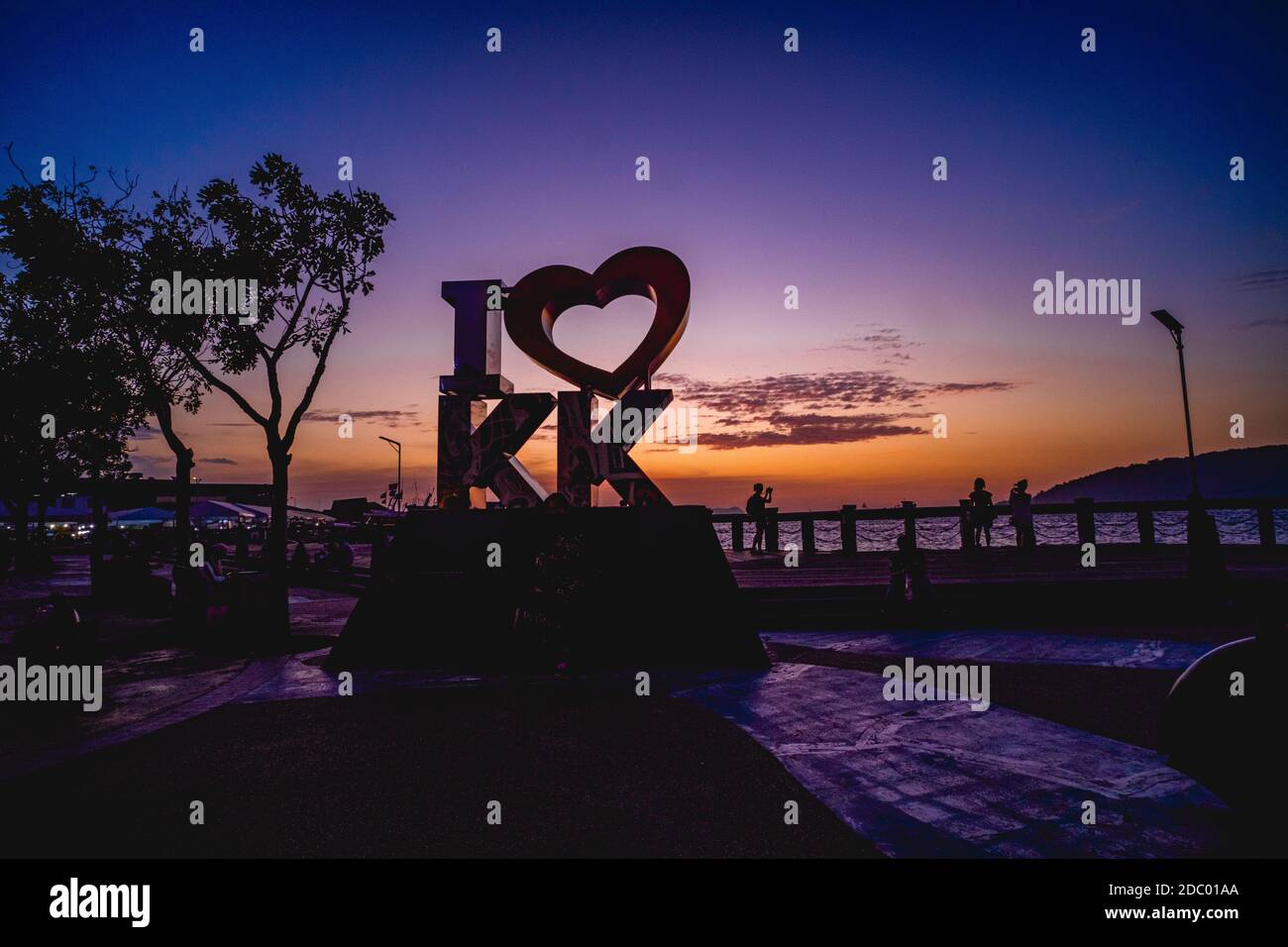Seafront of Kota Kinabalu with the I Love KK signage and people admiring the sunset view of the sea. Stock Photo
