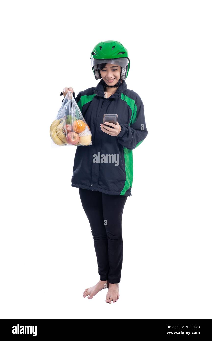 female uber delivery courier wearing helmet bring groceries in the bag